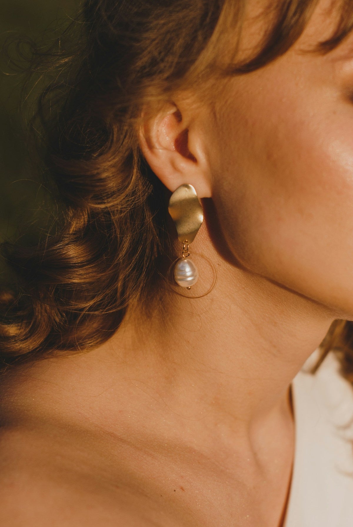 Mujer luciendo arete con perla