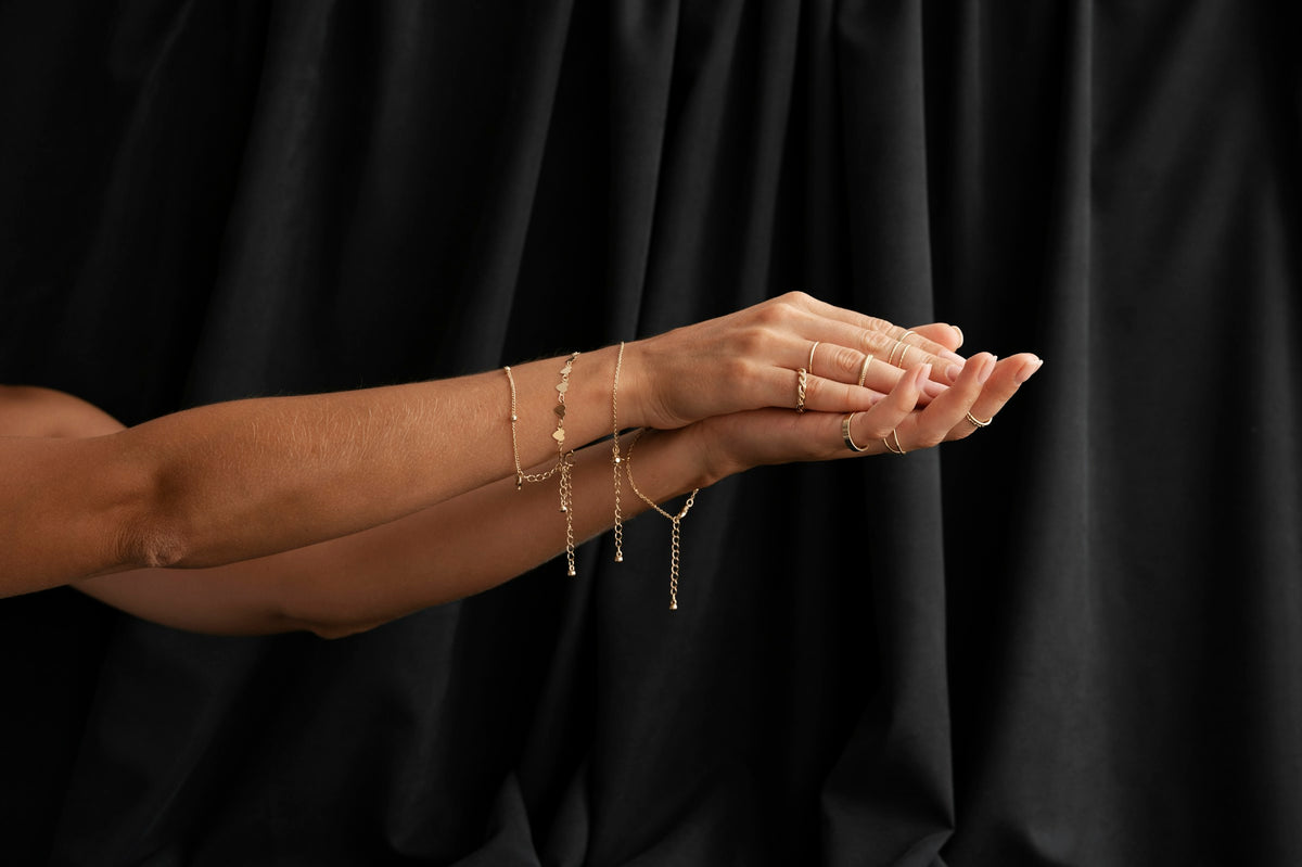 Mujer con vestido negro luciendo pulseras doradas